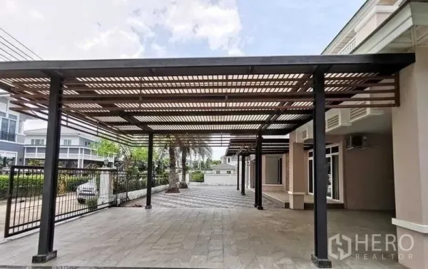 บ้าน ขายในLat Krabang, Bangkok - ประตูรั้วทางเข้ากว้างพร้อมกันสาดจอดรถคู่และลานปูพื้นด้านหน้า