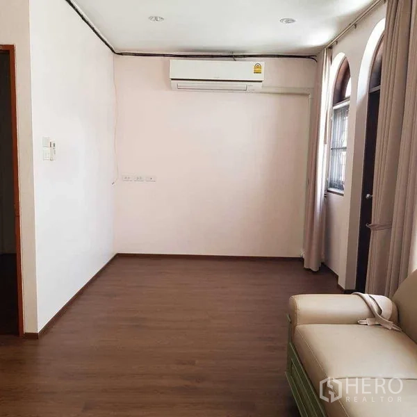 Home Office for rent in Watthana, Bangkok - Compact lounge with sofa, air-conditioning and arched windows.