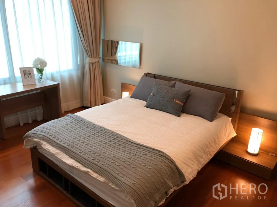 公寓 出租或出售在Khlong Toei, Bangkok - 明亮卧室，双人床、床头柜、书桌与带窗帘的大窗户。