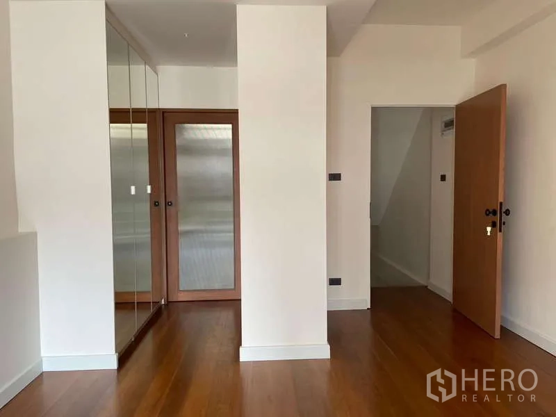 สำนักงานที่บ้าน ให้เช่าในWatthana, Bangkok - ห้องนอนมีตู้เสื้อผ้าบานกระจก พื้นไม้ และประตูไม้.