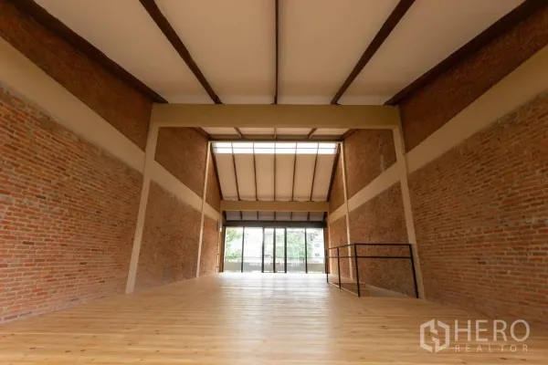 Home Office for rent in Watthana, Bangkok - Loft‑style workspace showing skylight and beams over polished wood floor.