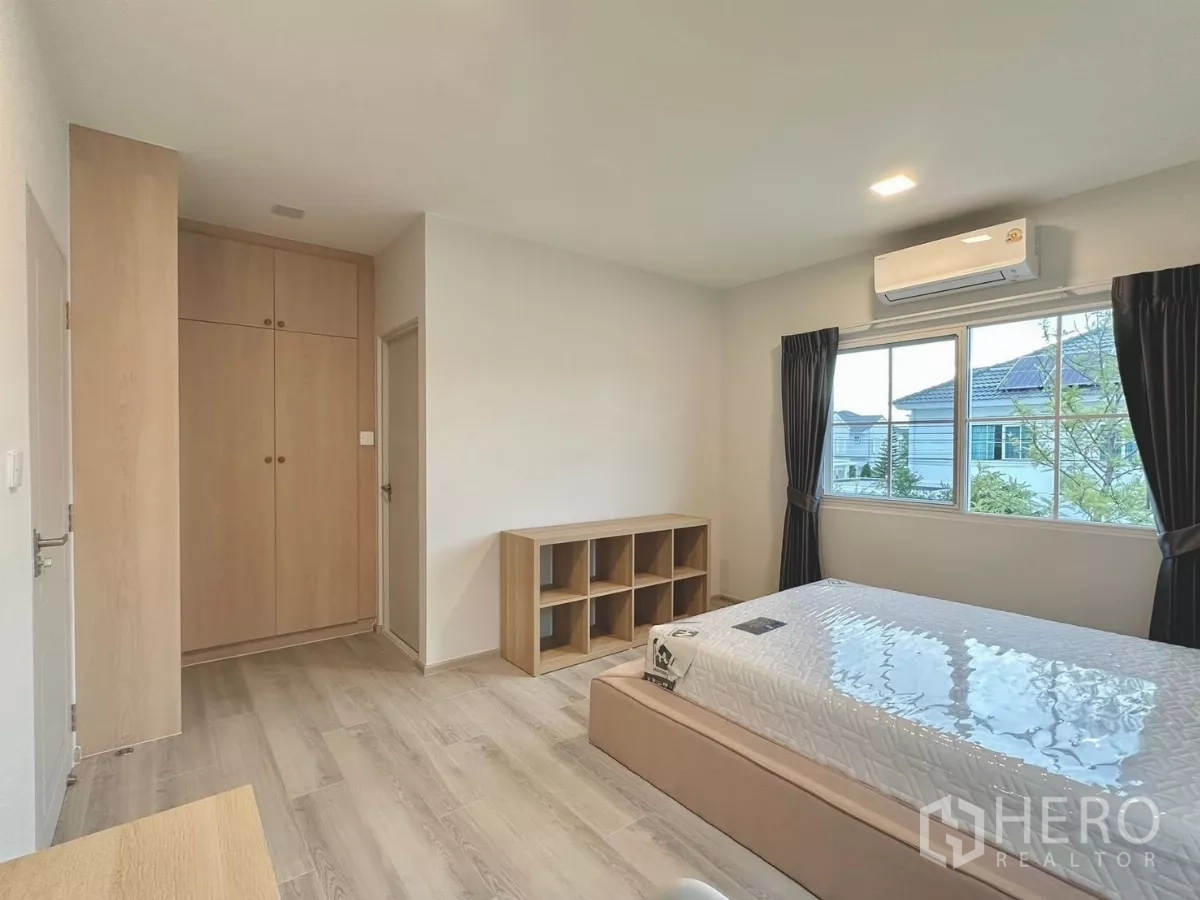 独立式住宅 出租在Bang Phli, Samut Prakan - 客卧另一视角，设衣柜、置物架与中性色调装饰。