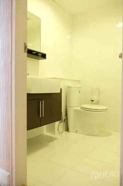 คอนโด ขายในKhlong San, Bangkok - ห้องน้ำโทนขาวสะอาด พร้อมอ่างล้างหน้า ตู้ใต้ซิงก์ และโถสุขภัณฑ์.