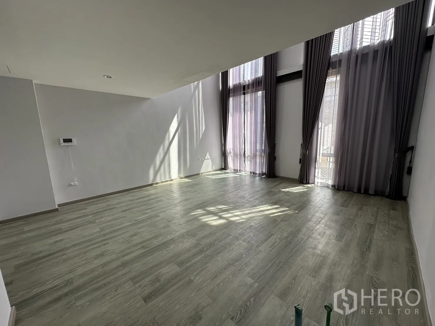 带办公室的家 出租或出售在Suan Luang, Bangkok - 明亮房间，落地玻璃门、纱帘与木纹地板。