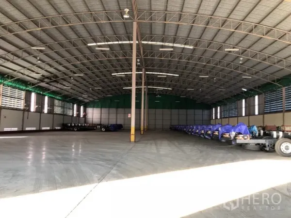 Factory for rent in Bang Pakong, Chachoengsao - Spacious factory interior showing high clear-span steel roof, polished concrete floor, louvered side ventilation and ample lighting.