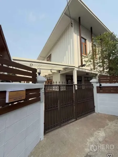 บ้าน ให้เช่าในKhlong Toei, Bangkok - ด้านหน้าบ้านเดี่ยวสองชั้น หลังคาจั่วสูง ระแนงไม้ พร้อมประตูเหล็กดัด