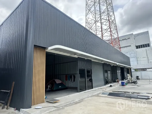 Warehouse for rent in Suan Luang, Bangkok - Contemporary row of warehouse units with roller shutter doors and a covered loading apron.