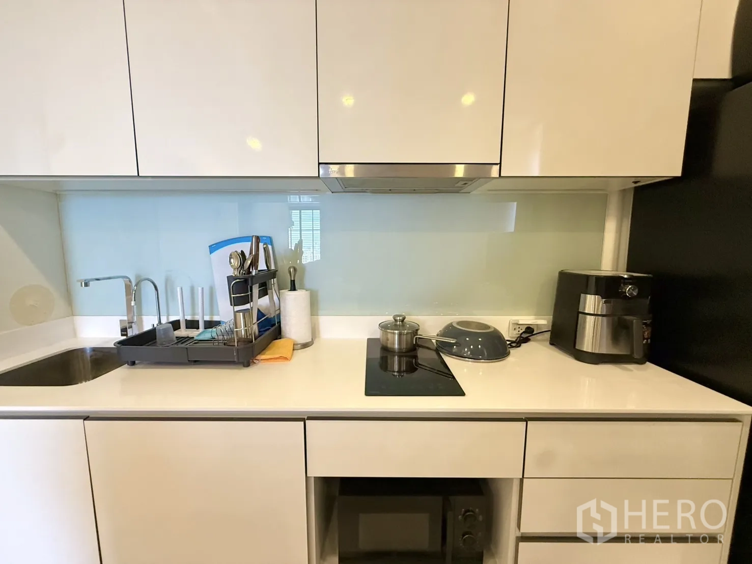 Condominium for sale in Chatuchak, Bangkok - Close-up of kitchen counter with sink, induction hob, and small appliances.