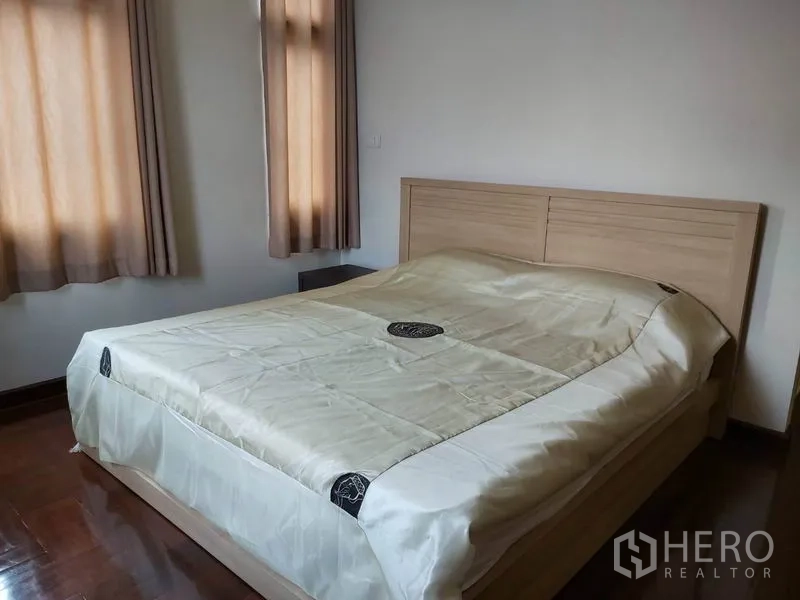 公寓 出租在Watthana, Bangkok - 第二卧室配双人床，双窗配窗帘与亮面木地板。