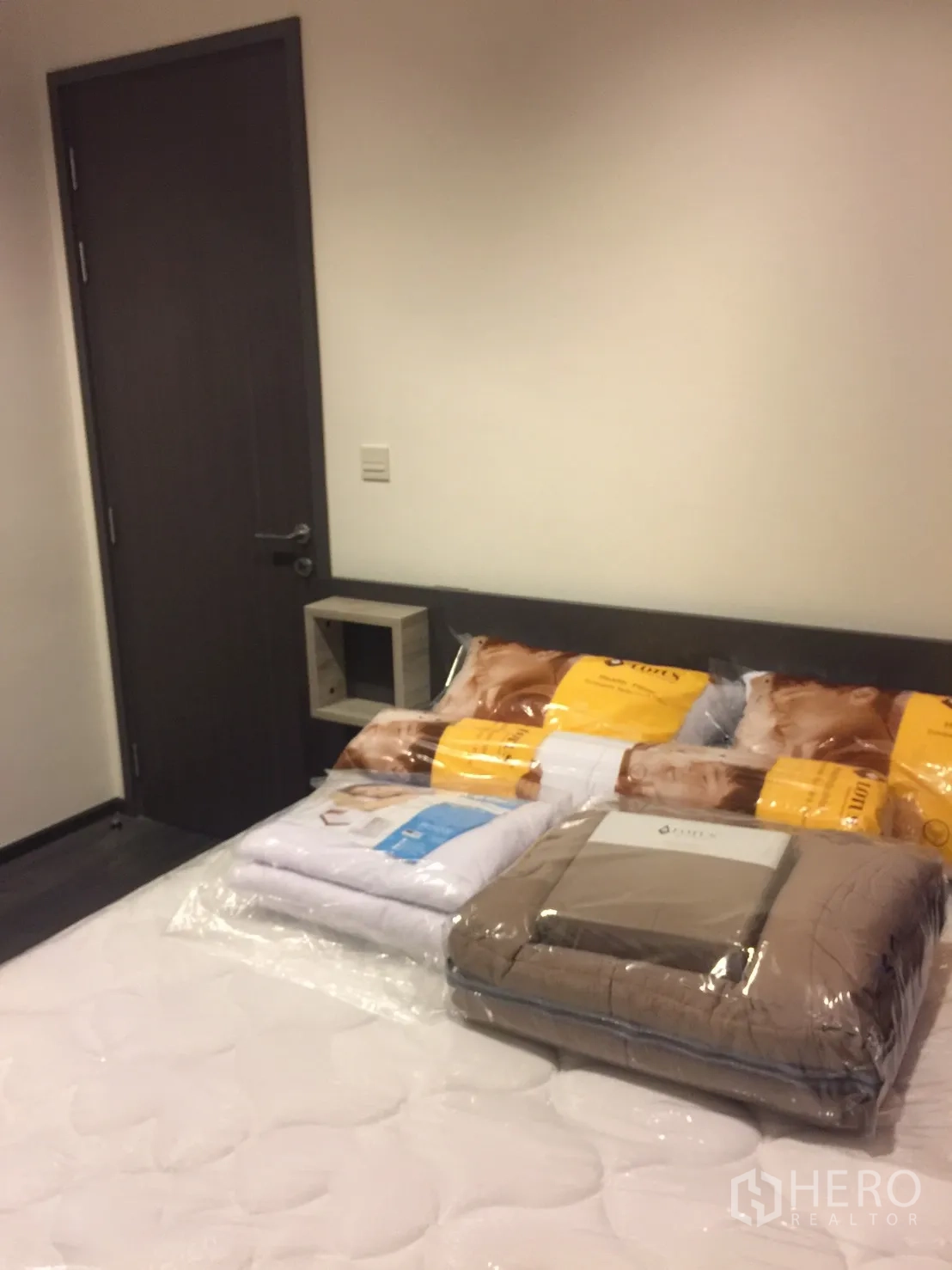 公寓 出租在Watthana, Bangkok - 卧室配大床与深色木门，床品全新。