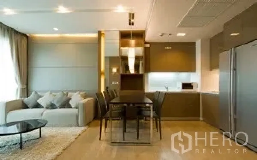 คอนโด ให้เช่าในKhlong Toei, Bangkok - พื้นที่นั่งเล่นและรับประทานอาหารแบบโอเพนแพลน โซฟา โต๊ะกระจก และครัวบิลท์อินสไตล์โมเดิร์นในคอนโดกรุงเทพฯ