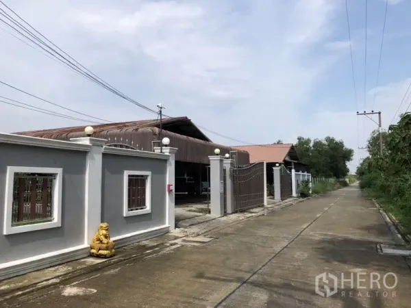 บ้าน ขายในLam Luk Ka, Pathum Thani - ทางเข้าพร้อมกำแพงรั้วสูงและประตูเหล็กเลื่อนริมถนนเงียบสงบ