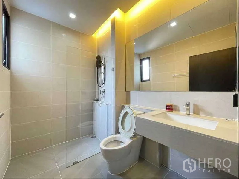 Detached House for rent in Bang Sue, Bangkok - Modern bathroom with walk-in shower, backlit mirror and long vanity.