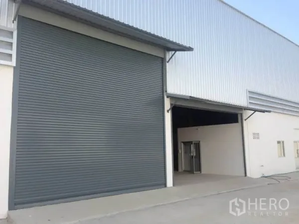 Warehouse for rent in Bang Bua Thong, Nonthaburi - Warehouse facade with oversized rolling shutter and open loading entrance.