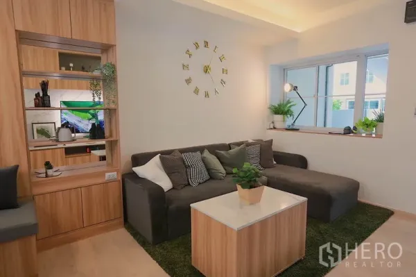 ทาวน์เฮาส์ ให้เช่าในPrawet, Bangkok - ห้องนั่งเล่นอบอุ่น โซฟาเข้ามุม นาฬิกาติดผนัง และชั้นไม้