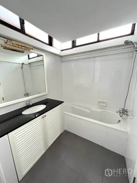 คอนโด ให้เช่าในWatthana, Bangkok - ห้องน้ำพร้อมอ่างอาบน้ำและฝักบัว เคาน์เตอร์ท็อปสีดำและหน้าต่างเหนือศีรษะ