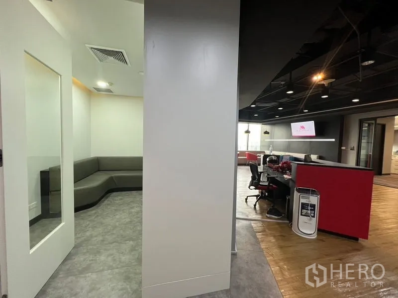 办公空间 出租在Huai Khwang, Bangkok - 接待与工作区一体，休息座位与黑色天花点缀。