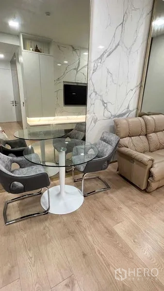 คอนโด ให้เช่าในWatthana, Bangkok - มุมทานอาหารแปลนเปิด โต๊ะกระจกทรงกลมข้างโซฟา และผนังลายหินอ่อน