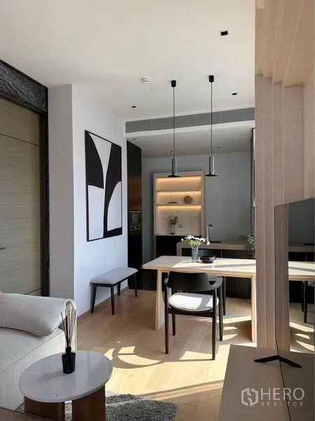 公寓 出租在Pathum Wan, Bangkok - 极简餐区，吊灯、抽象装饰画与紧凑型厨房相连。