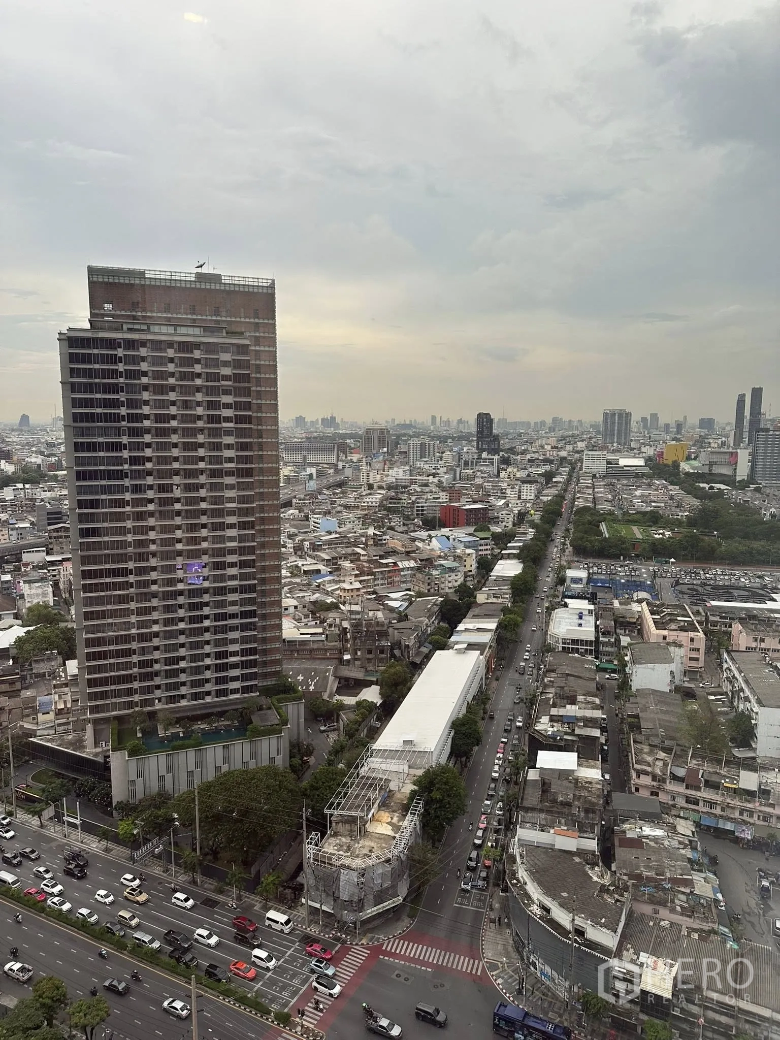 公寓 出租在Bang Rak, Bangkok - 高层城市远景，繁忙路口与高楼尽收眼底，天空多云。