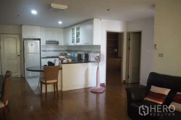 คอนโด ให้เช่าในPathum Wan, Bangkok - ครัวสีขาวรูปตัว U พร้อมเคาน์เตอร์บาร์ เชื่อมต่อห้องนั่งเล่น