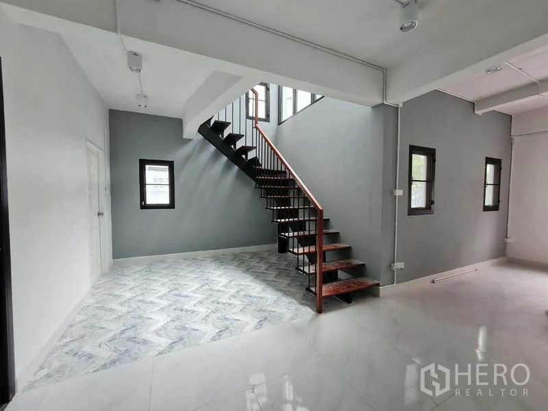 สำนักงานที่บ้าน ให้เช่าในLat Phrao, Bangkok - โถงโล่งพร้อมบันไดเหล็กไม้และผนังสีเทา