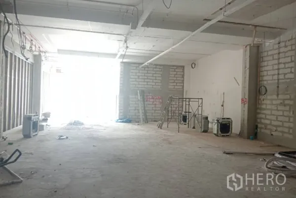 零售空间 出租在Khlong Toei, Bangkok - 高挑开放式商铺内部，正在施工，前方为大面积店面开口。