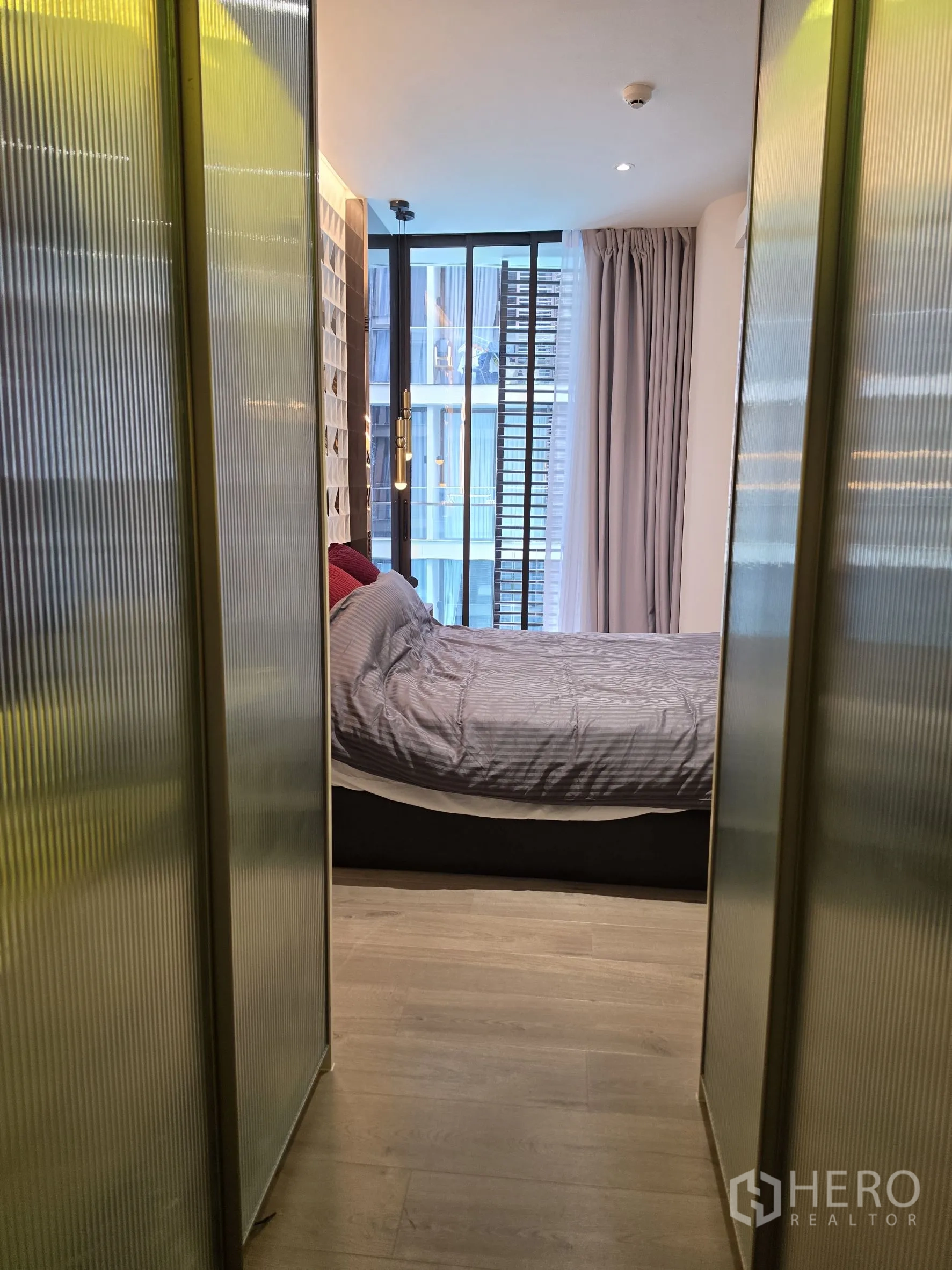 คอนโด for rent in Khlong Toei, Bangkok - โถงทางเดินมีตู้กระจกฝ้านำไปสู่ห้องนอนที่มีหน้าต่างเต็มบาน