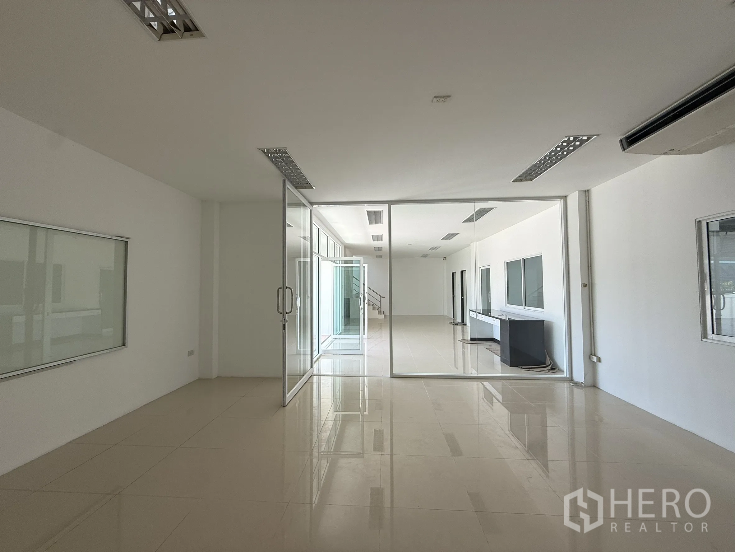 Warehouse for rent or sale in Bang Bo, Samut Prakan - Open‑plan office with glass partitions and glossy tiled floors.