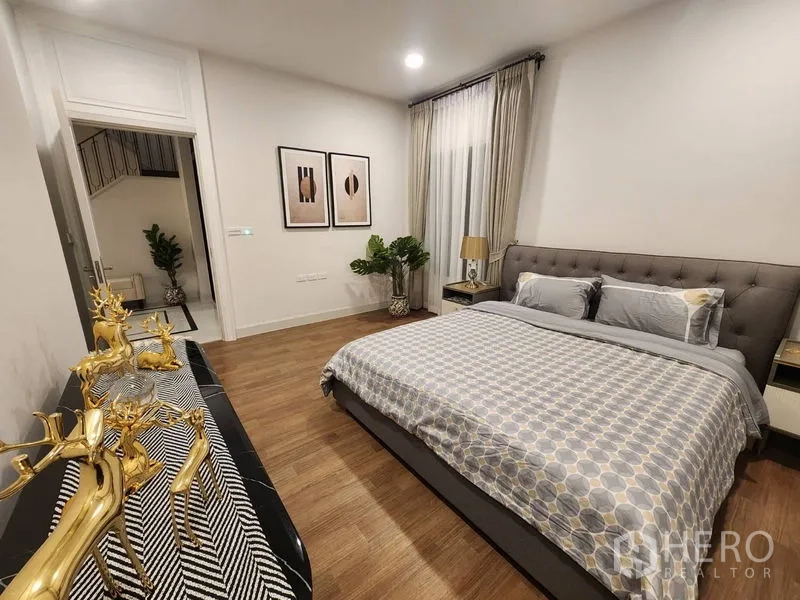 Detached House for rent or sale - Spacious bedroom with king bed, wood floors and doorway to the staircase hall