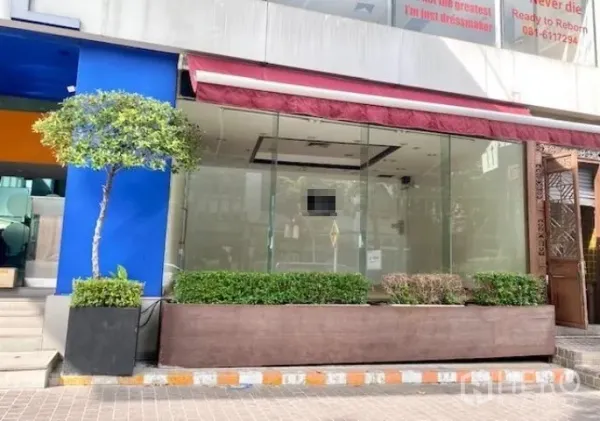 零售空间 出租在Pathum Wan, Bangkok - 临街店面，整面玻璃橱窗、红色遮阳篷与长条花槽。