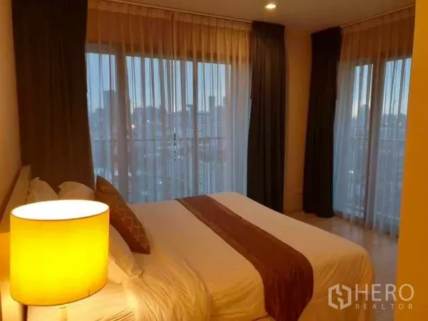 公寓 出租在Watthana, Bangkok - 卧室设落地窗与纱帘，享开阔城市景观。