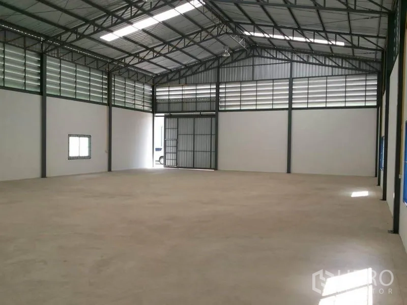 货栈 出租在Lam Luk Ka, Pathum Thani - 375㎡仓库内部，高钢架屋顶、通风百叶及大型滑动进出门。