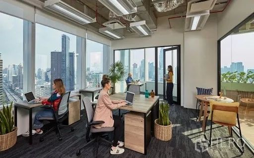 办公空间 出租在Pathum Wan, Bangkok - 带城市天际线景观的大窗私密办公室与现代办公桌。