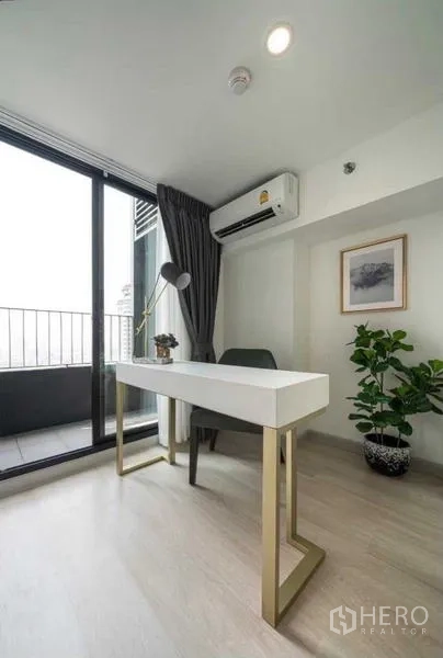 Condominium for rent in Sathon, Bangkok - Minimal study corner with desk and balcony door.