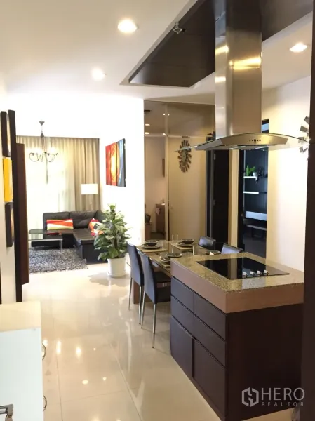 公寓 出租在Khlong Toei, Bangkok - 曼谷公寓开放式布局，带中岛厨房、四人餐桌与沙发客厅。