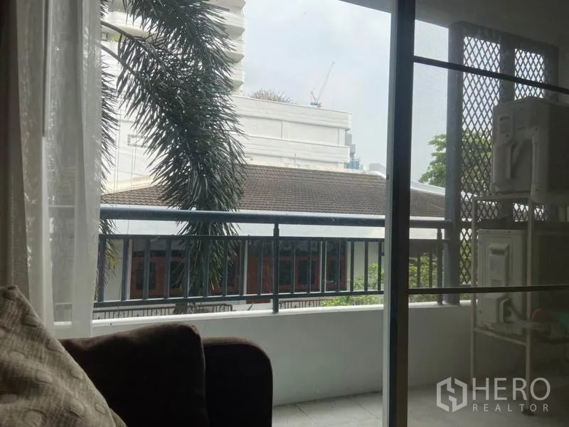 คอนโด ให้เช่าในWatthana, Bangkok - ระเบียงส่วนตัวมองเห็นต้นปาล์มและอาคารโลว์ไรส์ใกล้เคียง พร้อมราวเหล็ก