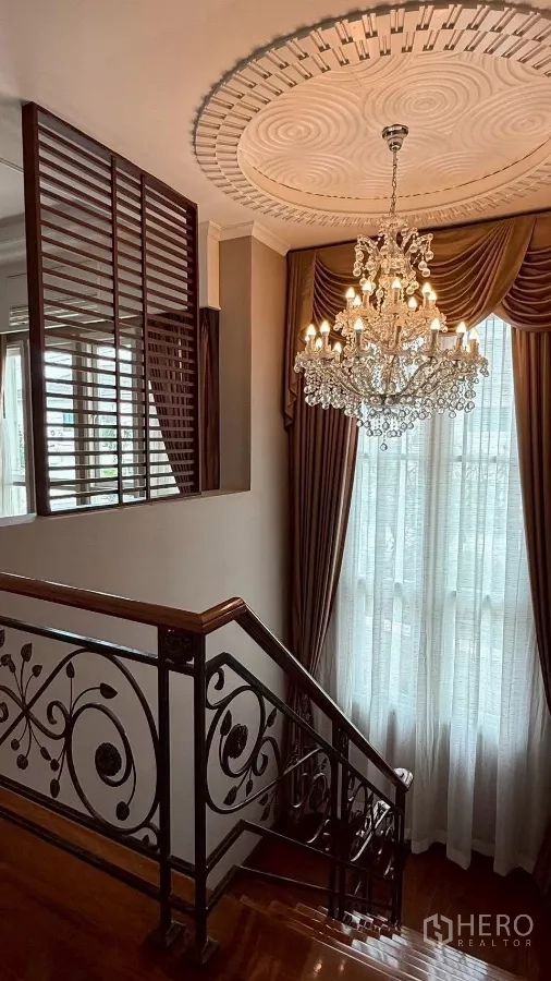 Detached House for rent or sale in Bang Phli, Samut Prakan - Staircase with ornate wrought‑iron railing and crystal chandelier