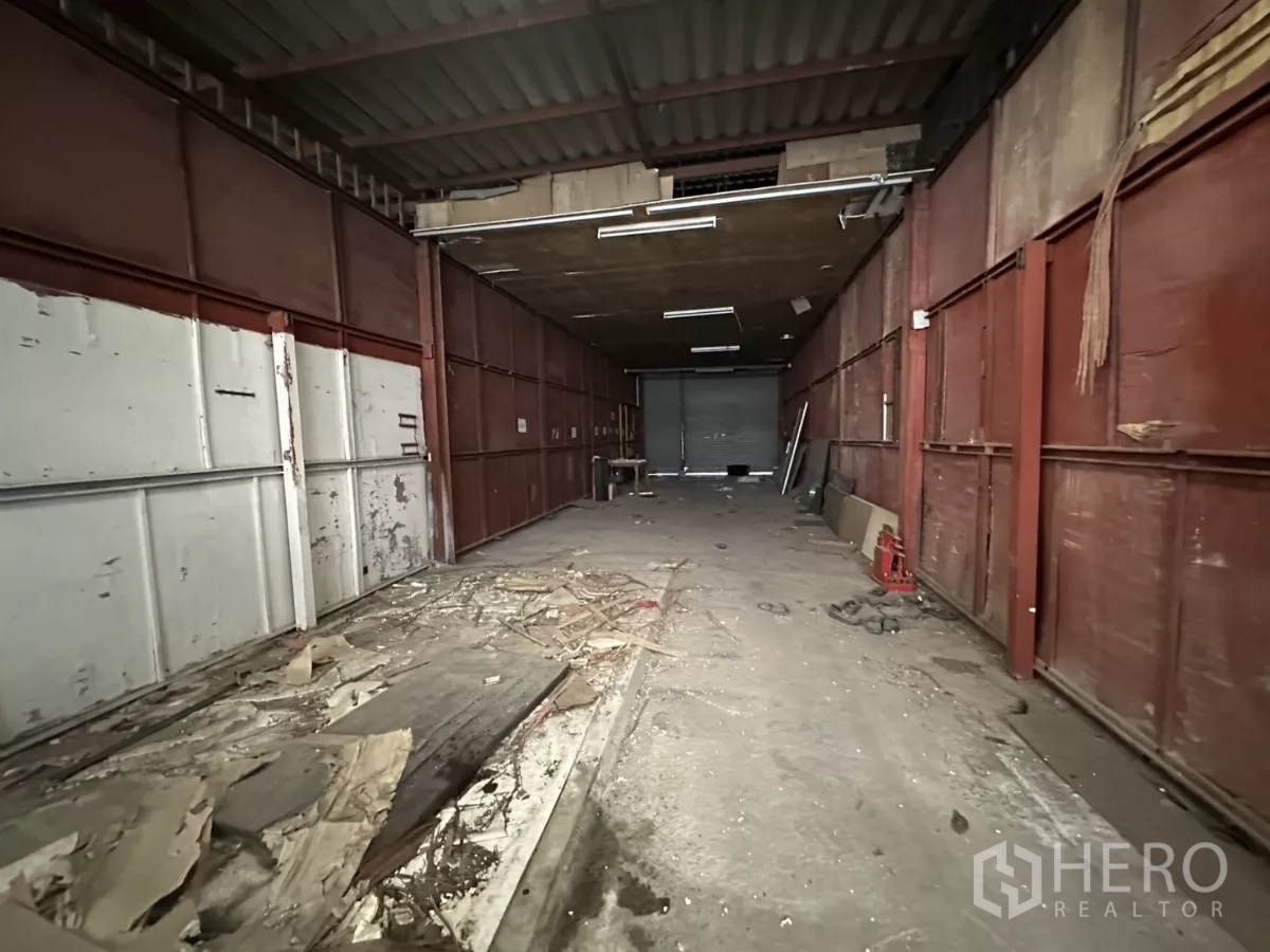 Warehouse for rent or sale in Yan Nawa, Bangkok - Long loading aisle with metal wall panels, overhead lighting and roller-door access.