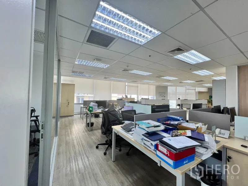 办公空间 出租 - 走廊视角，玻璃隔间的私人办公室与共享工位并列。