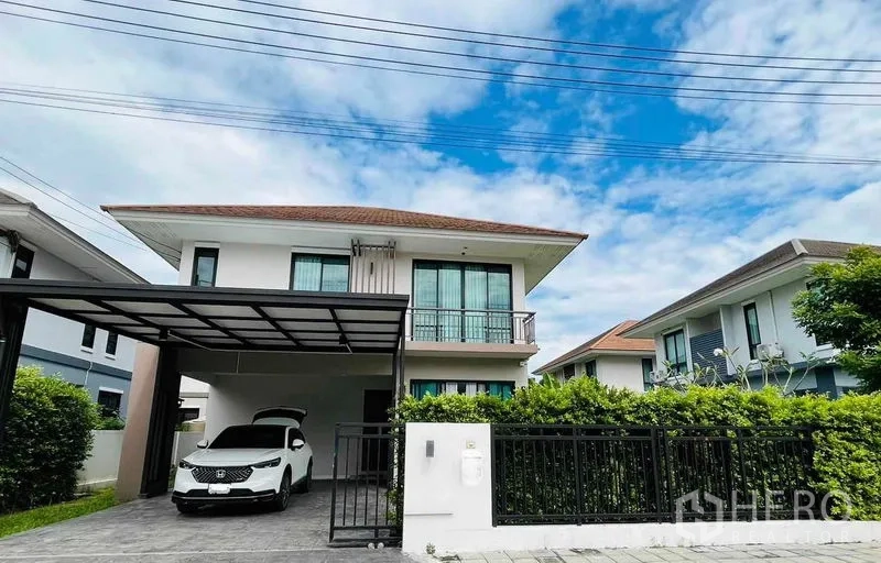 Detached House for rent or sale in Thanyaburi, Pathum Thani - Front elevation of a two-storey detached house with gate and covered carport.
