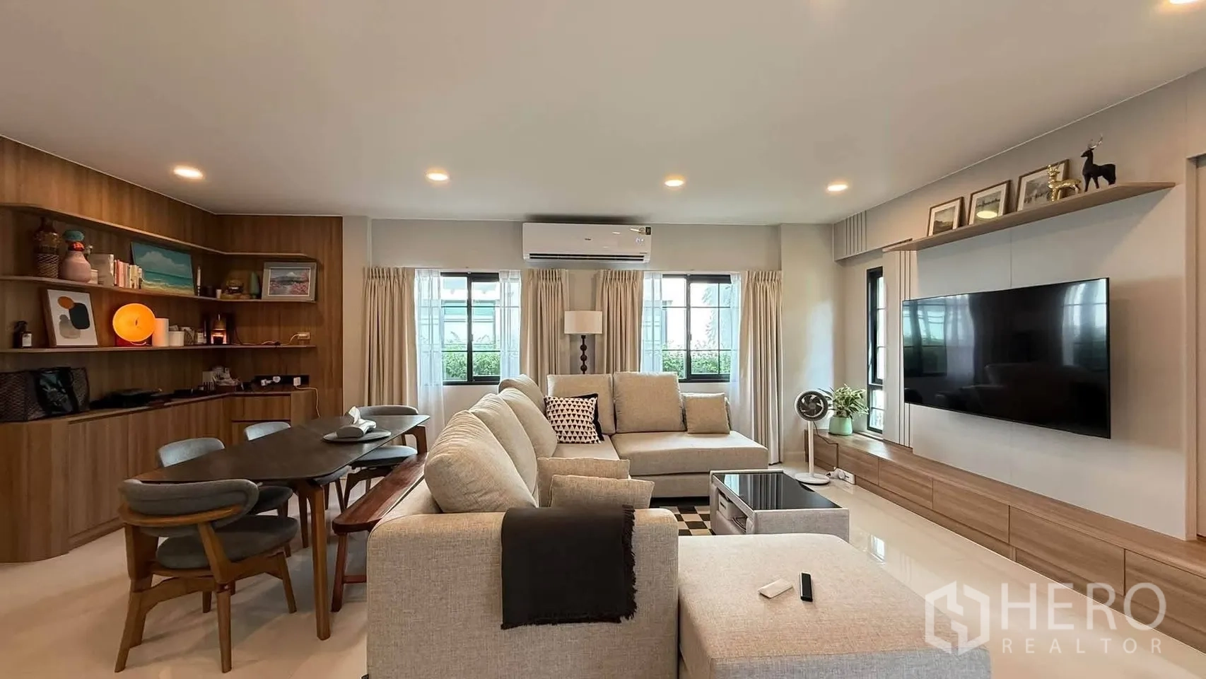 独栋房屋 for rent in Bang Phli, Samut Prakan - 通透客厅，多扇窗户、媒体墙与绿植装饰。