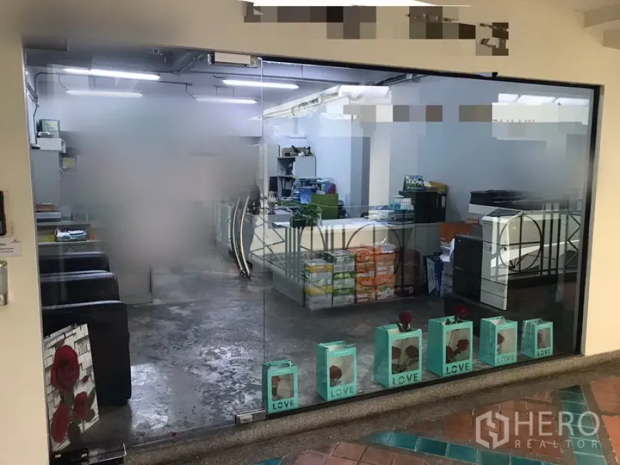 Office Space for rent in Watthana, Bangkok - Glass-front office entrance showing open-plan workspace, bright ceiling lights and polished concrete floor.