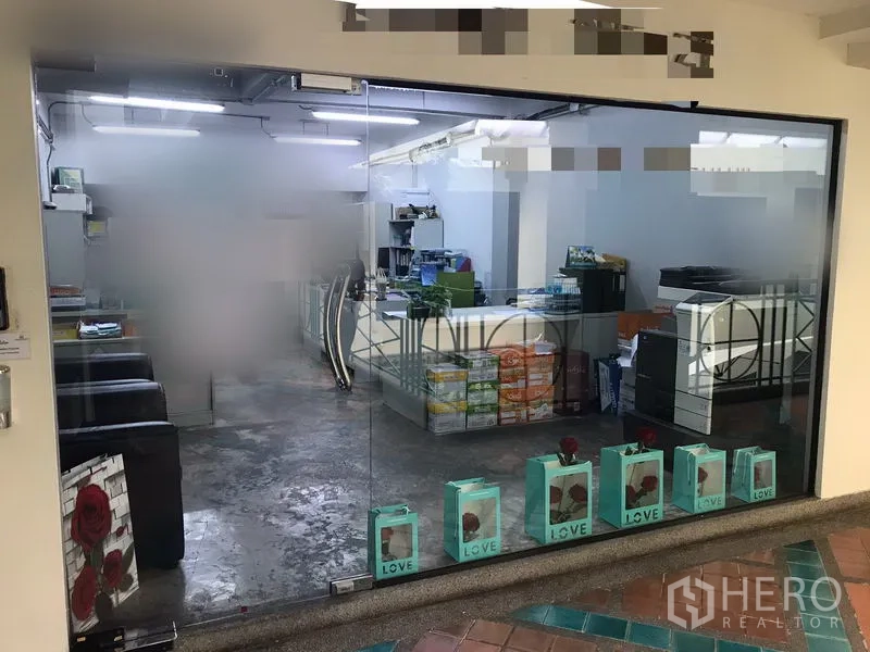 Office Space for rent in Watthana, Bangkok - Glass-front office entrance showing open-plan workspace, bright ceiling lights and polished concrete floor.