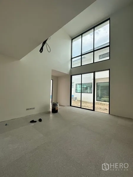 独立式住宅 出租在Watthana, Bangkok - 挑高客厅，巨幅落地窗最大化引入日光和庭院景观。