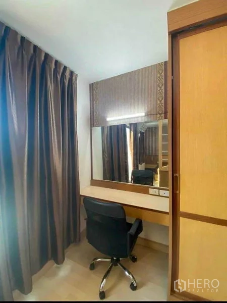 Townhouse for rent in Suan Luang, Bangkok - Study nook with wide mirror, desk, swivel chair and blackout curtains.
