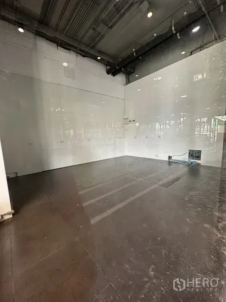 พื้นที่ขายปลีก ให้เช่าในKhlong Toei, Bangkok - ภายในพื้นที่ร้านค้า 63 ตร.ม. เพดานสูงเปลือย ผนังสีขาว พื้นกระเบื้องสีเข้ม พร้อมตกแต่ง