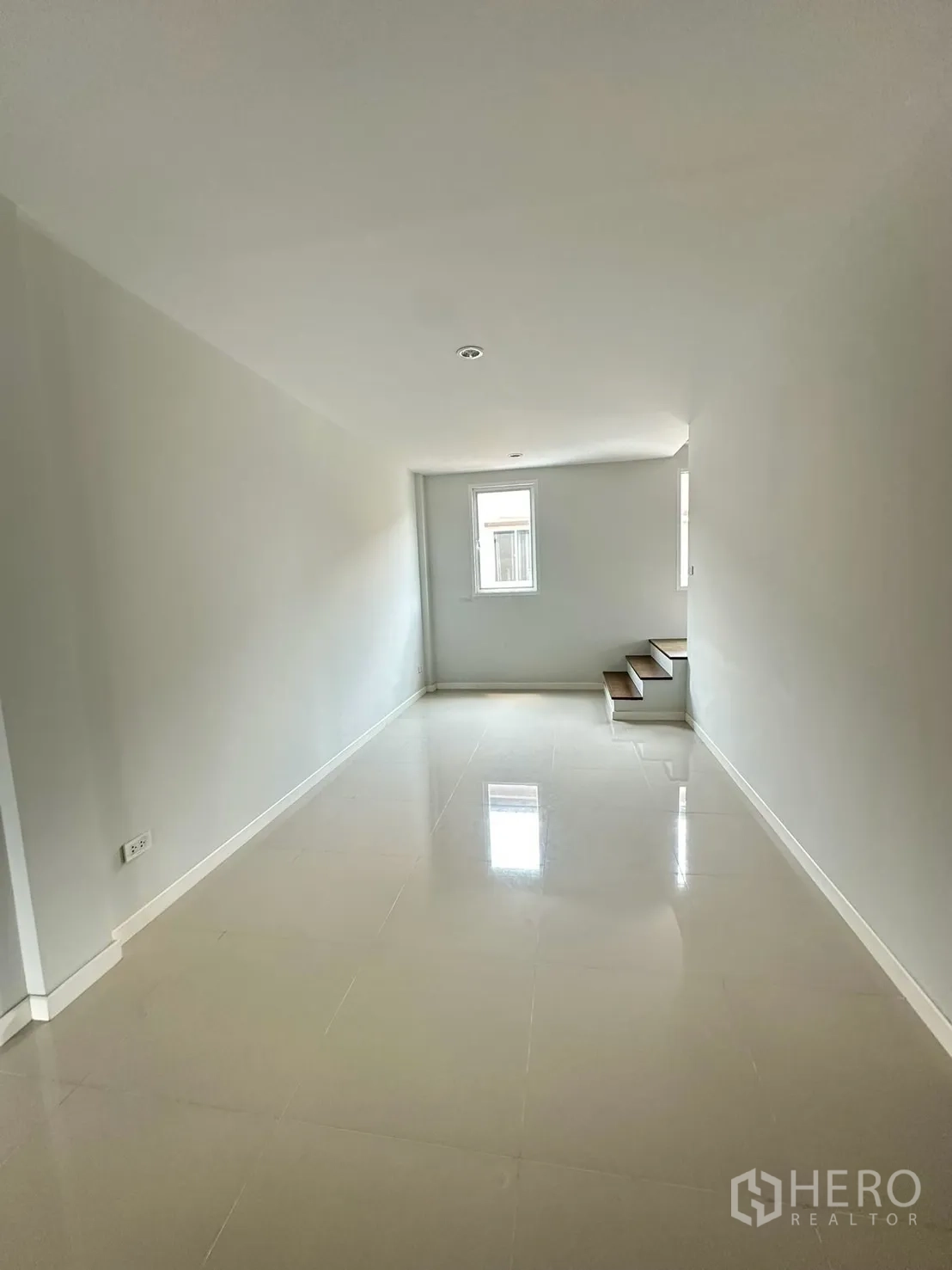 Home Office for rent in Khlong Luang, Pathum Thani - Hallway with glossy tiled floor leading to a small staircase.