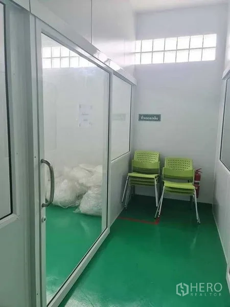 工厂 出售在Bang Pa-in, Phra Nakhon Si Ayutthaya - 小型玻璃房内有叠放椅子和白色袋装物料。