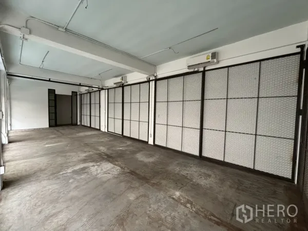 พื้นที่ขายปลีก ให้เช่า - ภายในสไตล์อุตสาหกรรม พร้อมแอร์แบบแยกส่วนและผนังบานเลื่อนตะแกรงเหล็กตลอดแนว